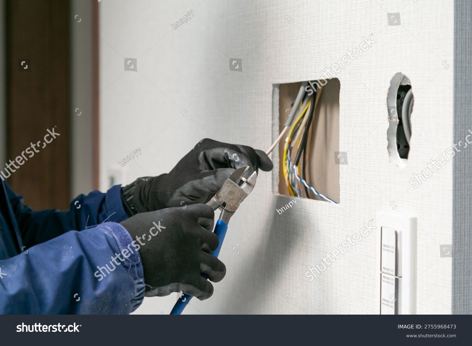 stock photo close up of professional electrician hands cutting electrical wire with pliers in a wall home 2755968473
