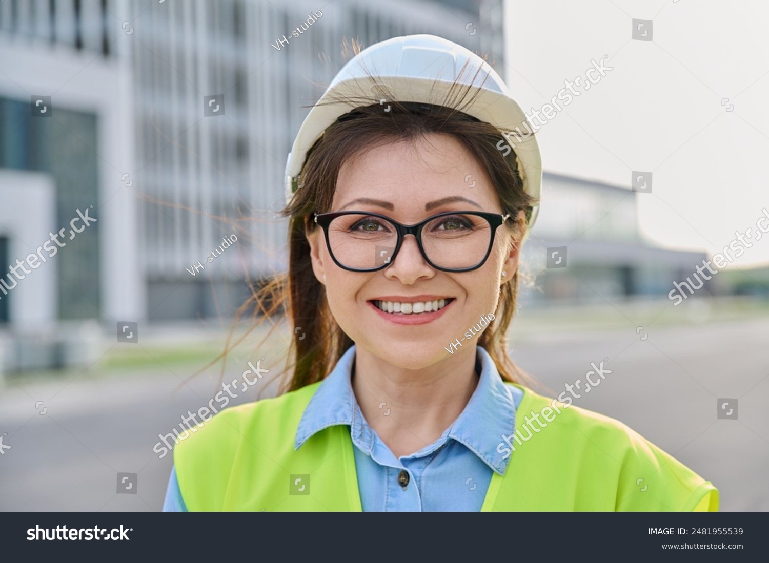 stock photo headshot portrait of woman in safety helmet vest looking at camera outdoors 2481955539