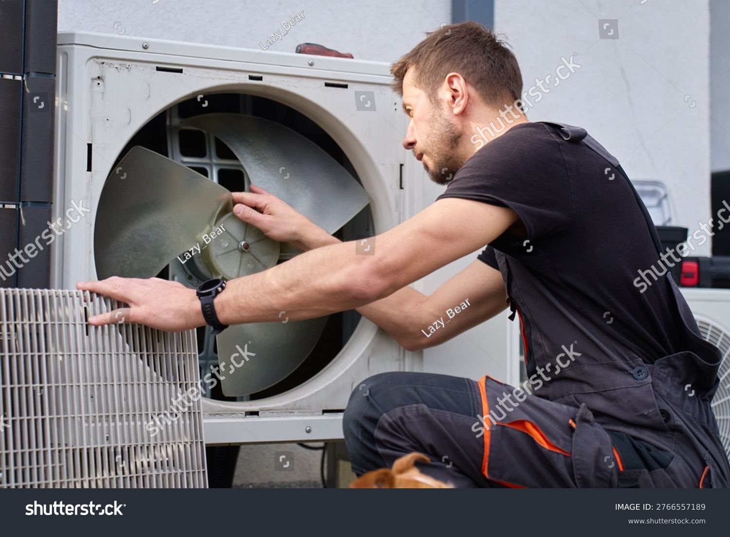 stock photo technician removing front cover and inspecting fan inside outdoor heat pump unit concept of hvac 2766557189
